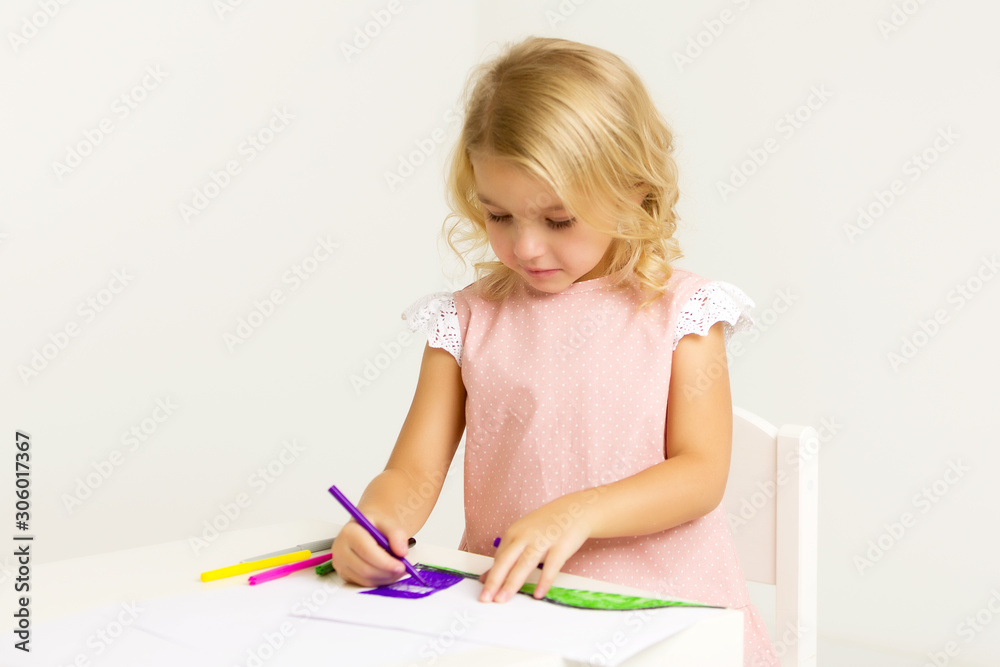 A little girl is drawing at the table. A little girl is drawing at the table.
