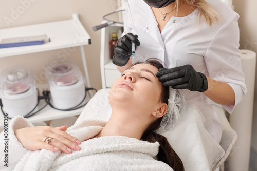 Woman gets injection in her face. Beauty woman giving beauty injections. Young woman gets beauty facial injections in the cosmetology salon. Face aging injection. Aesthetic Medicine, Cosmetology