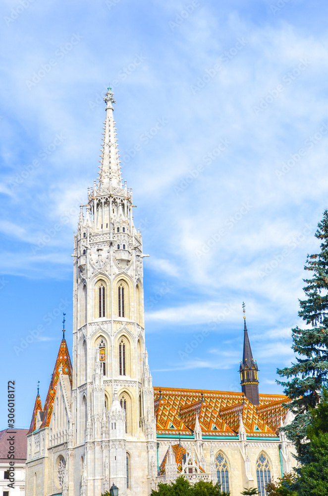Spire of the Matthias Church in Budapest, Hungary on a vertical photo. Roman Catholic church built in the Gothic style. Located in front of the Fisherman's Bastion in Buda Castle District