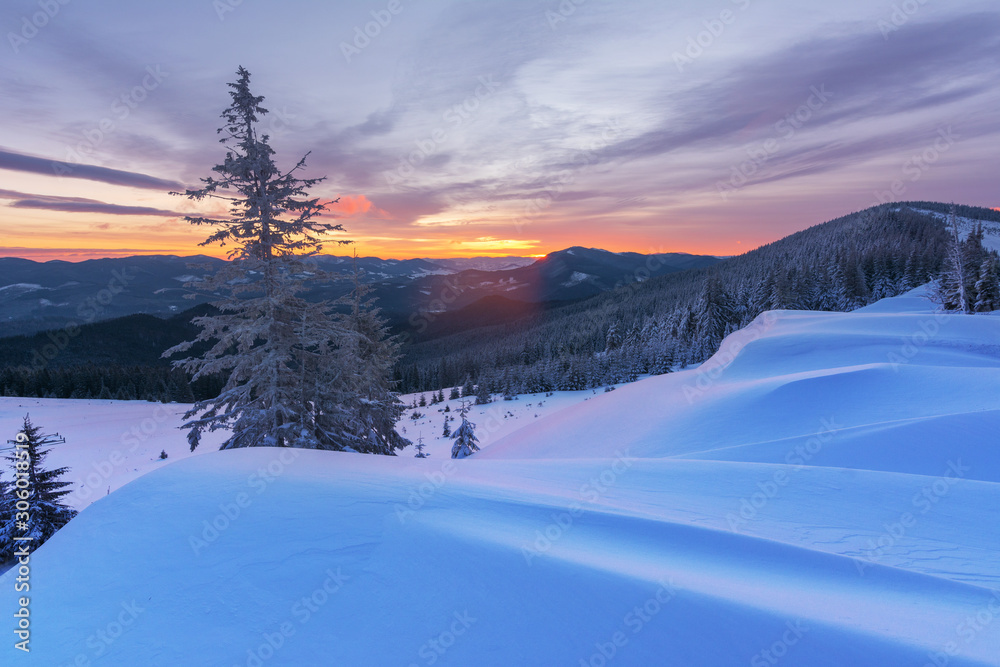 Colorful winter dawn on the mountain valleys in the Ukrainian Carpathian Mountains.	