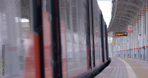 A guy rolls a disabled person in a wheelchair into a train car of ground metro photo