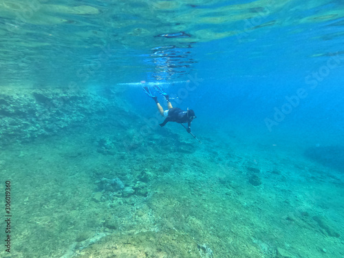Underwater photo of spear fishing gun scuba diver in tropical exotic sea