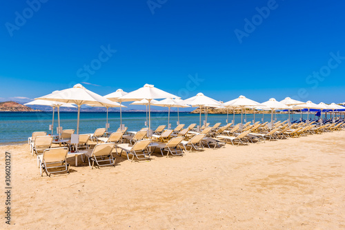 Sunbeds with umbrellas on Agios Georgios beach, very popular resort on Naxos island, Greece. © vivoo