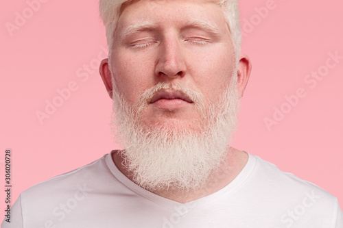 Calm adult albino man with closed eyes