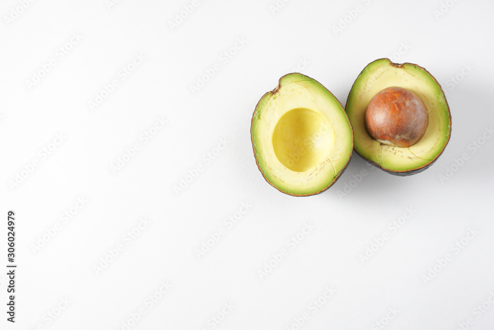 A pair of avocado halves on a white background in the top right with copy space on the bottom left