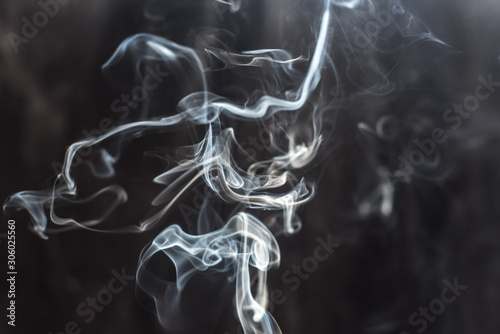 Image of backlit puffs of smoke, on a dark background.