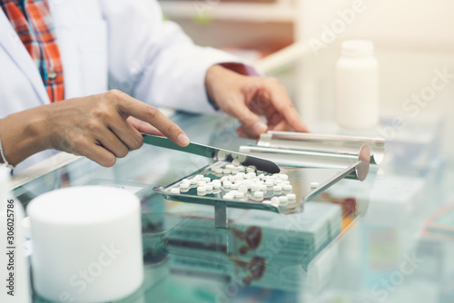 Medicine tablets on counting tray with counting spatula at pharmacy
