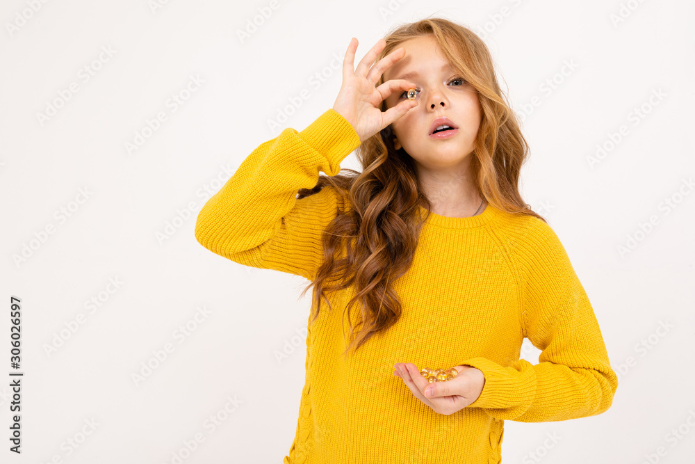 European girl looking through the lens holding a handful of glass balls in hand on a white background European girl looking through the lens holding a handful of glass balls in hand on a white background
