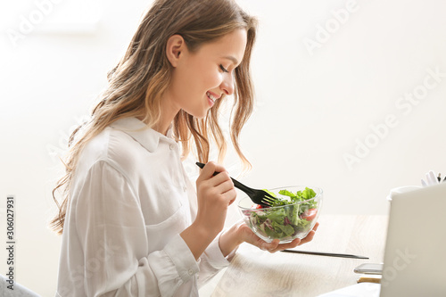 Carta da parati Woman eating healthy vegetable salad in office