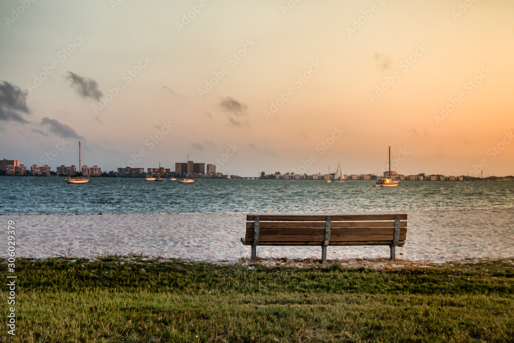 Empty bench in front of a bay with boats