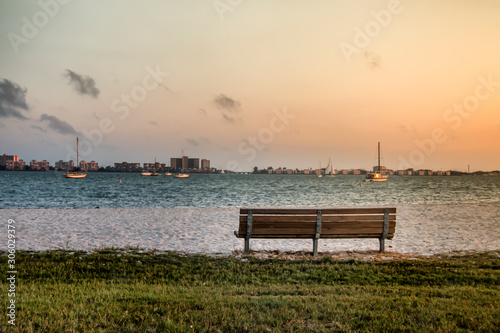 Empty bench in front of a bay with boats © Benjamin