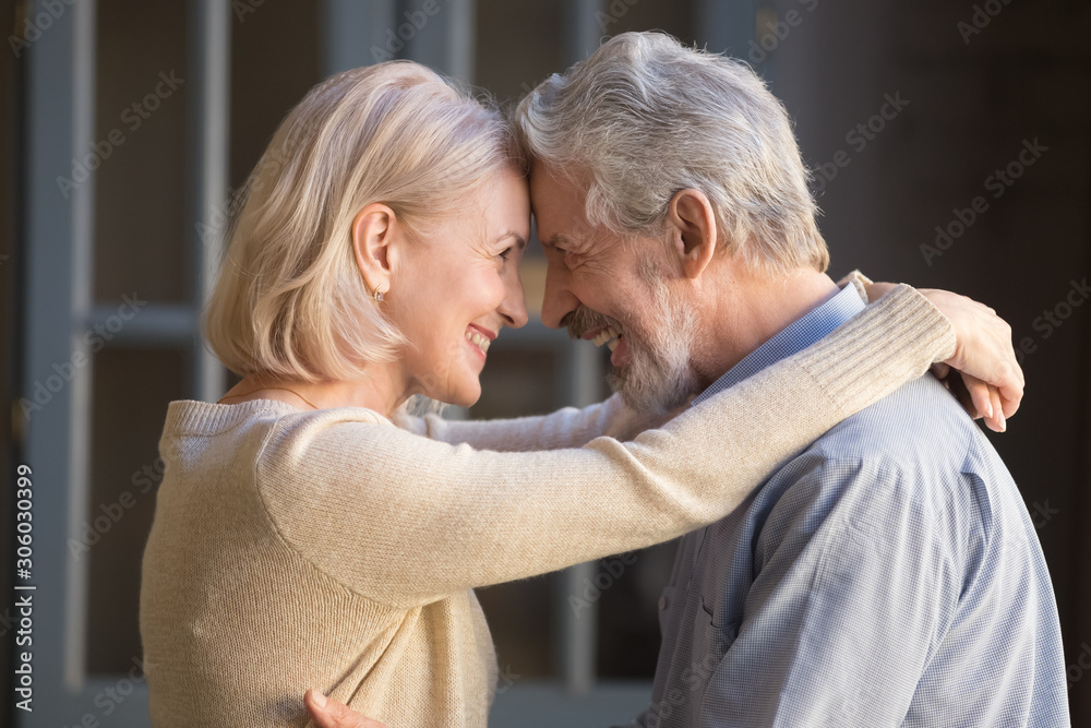Αυτοκόλλητο Elderly cheerful couple embracing looks at each other with love