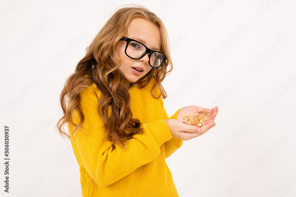 European girl in glasses holds in his hand a handful of glass crystals similar to lenses over white background. European girl in glasses holds in his hand a handful of glass crystals similar to lenses over white background.