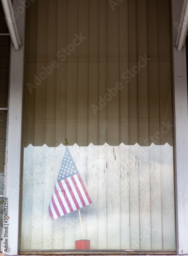 American flag behind window with blinds