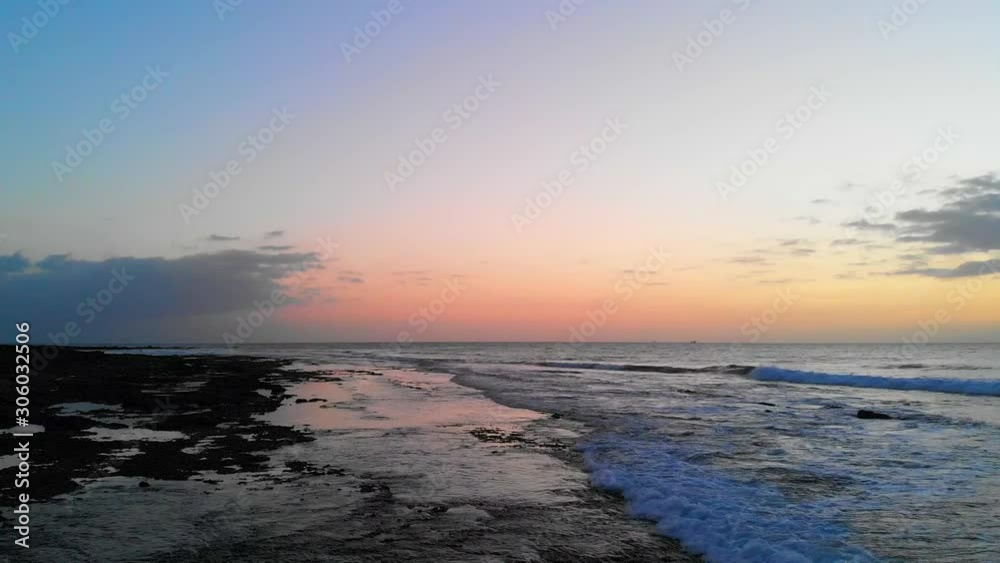 waves crashing into the rocky beach with a beautiful sunset in the background waves crashing into the rocky beach with a beautiful sunset in the background