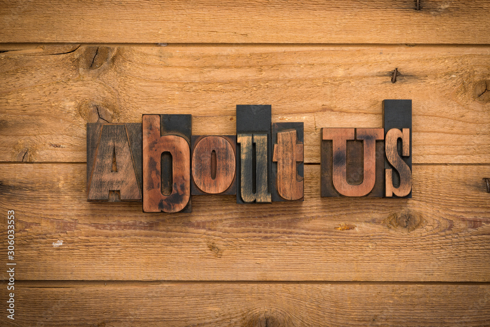 About us, phrase written with vintage letterpress printing blocks on rustic wood background
