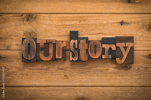 Our story, phrase written with vintage letterpress printing blocks on rustic wood background