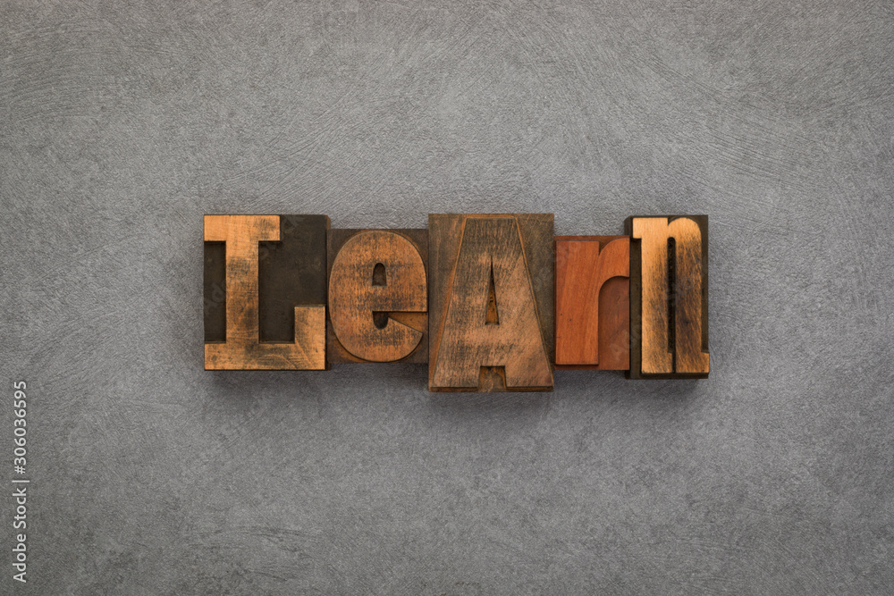 Fototapeta premium Learn, word written with vintage letterpress printing blocks on textured grey background