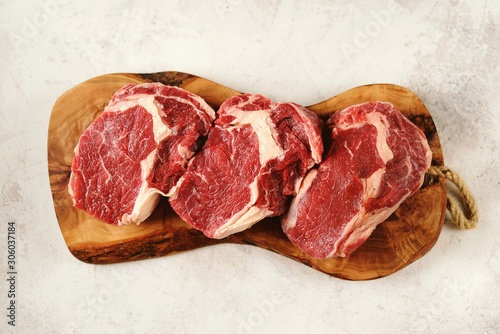 Fresh raw rib eye steak on a light background. Organic food. Top view.