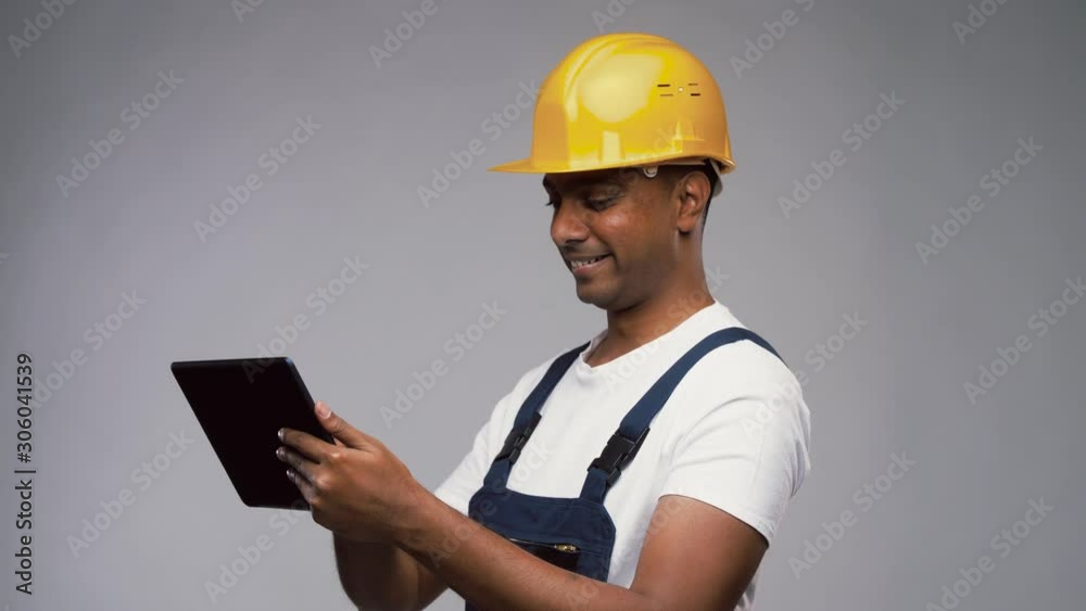 profession, construction and building - happy smiling indian worker or builder in helmet with tablet pc computer over grey background