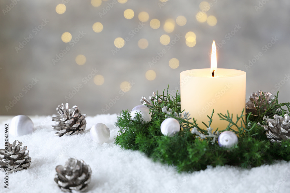 Burning candle with evergreen arrangment and christmas decoration,over gray with illuminaton background. Burning candle with evergreen arrangment and christmas decoration,over gray with illuminaton background.