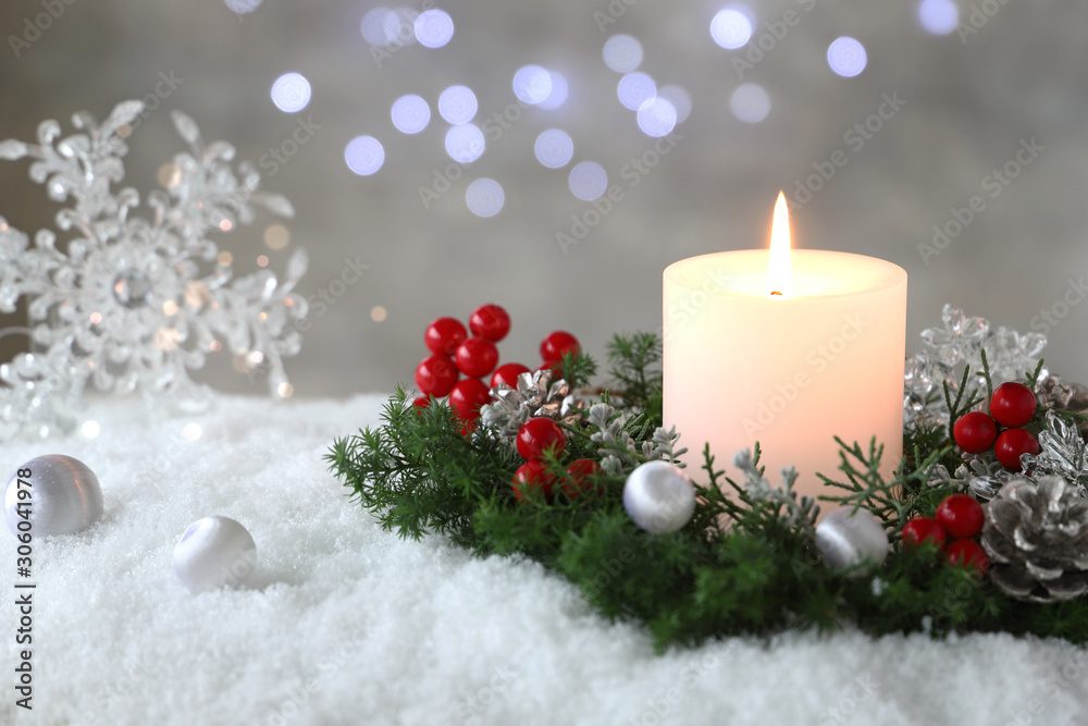 Burning candle with evergreen arrangment and christmas decoration,over gray with illuminaton background. Burning candle with evergreen arrangment and christmas decoration,over gray with illuminaton background.