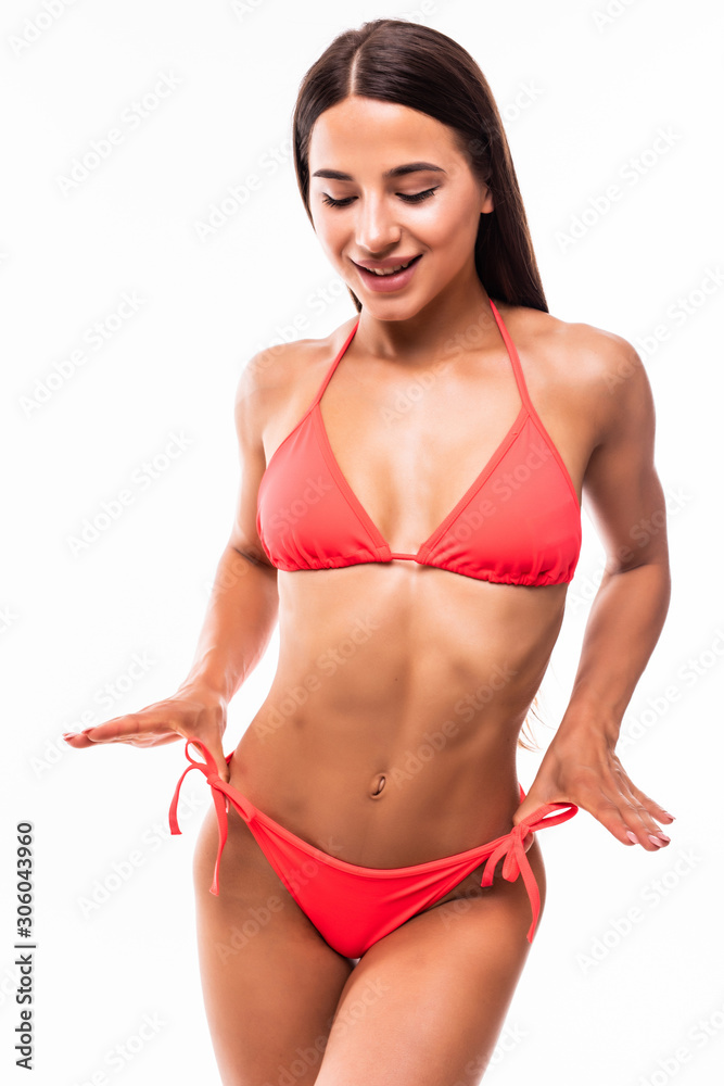 Fototapeta premium Young happy woman posing in a red bikini over white background