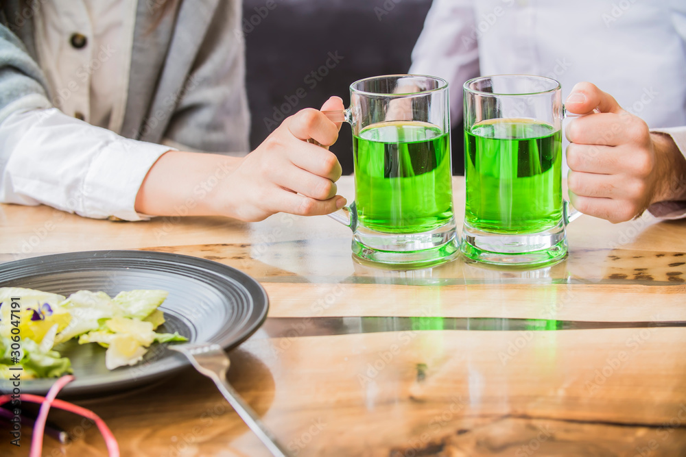 The company of young people celebrate St. Patrick's Day. They have fun at the bar. They are dressed in carnival headgear The company of young people celebrate St. Patrick's Day. They have fun at the bar. They are dressed in carnival headgear