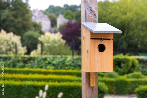 Fotografering Wooden birdhouse in park at summer day, Europe