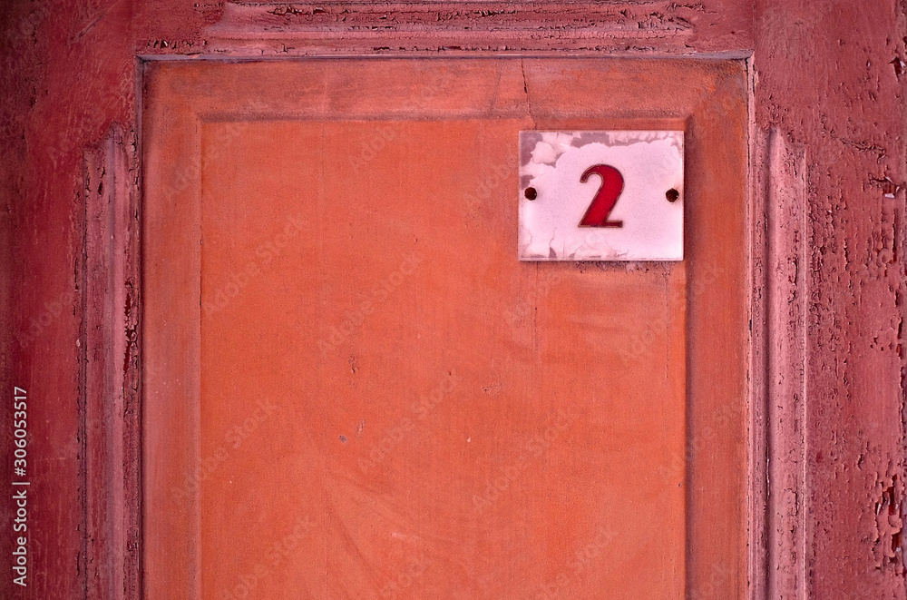 Number 2, two, digit on a wooden subdued red panel. Number 2, two, digit on a wooden subdued red panel.