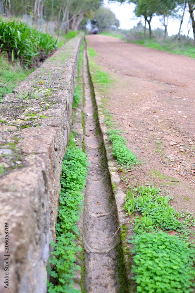 Old aqueduct and a stone wall at the edge of a country road. Old aqueduct and a stone wall at the edge of a country road.