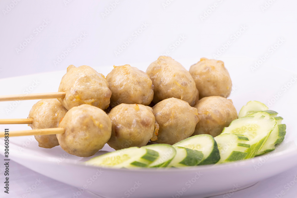 Grilled meatballs and cucumbers on a white plate Grilled meatballs and cucumbers on a white plate