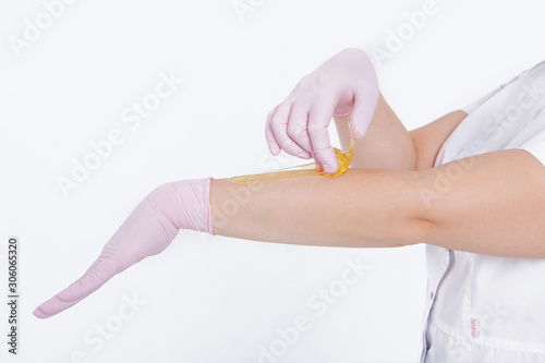Hands in rubber gloves close-up. doctor puts wax  honey. medic is preparing for depilation. Concept of medicine  medical instruments  health care  beauty industry  hair removal  natural material