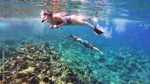 Man And Woman Swimming At Coral Reef In Tropical Blue Sea