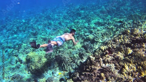 Asian Man Swimming Under Water At Coral Reef