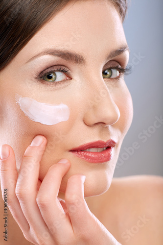 Beauty portrait of woman with white cream on face.