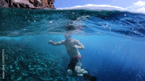 Man Swimming Beside Coral Reef In Tropical Blue Sea