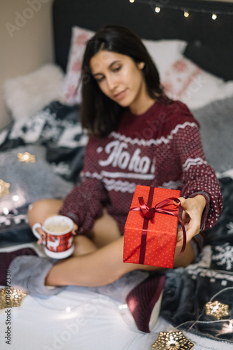 Obraz na plátně Out of focus girl holding in focus Christmas resent