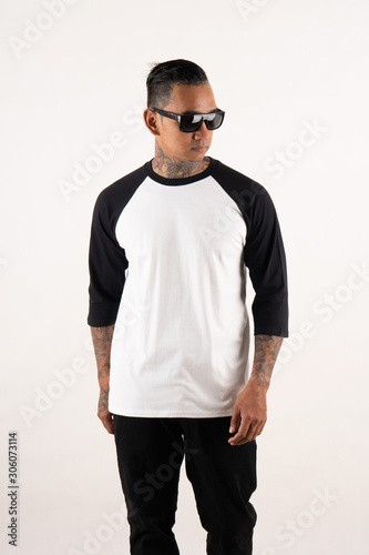Young man posing wearing black white raglan t shirt 3/4 sleeve isolated on background © DendraCreative