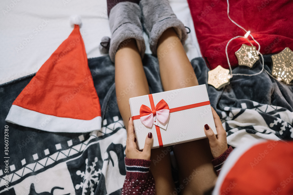 Top view of woman laying in bed with gift box Top view of woman laying in bed with gift box