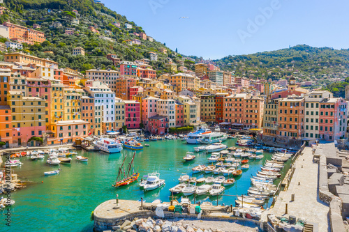 Camogli Harbor aerial view. Colorful buildings, boats and yachts moored in marina with green water. photo