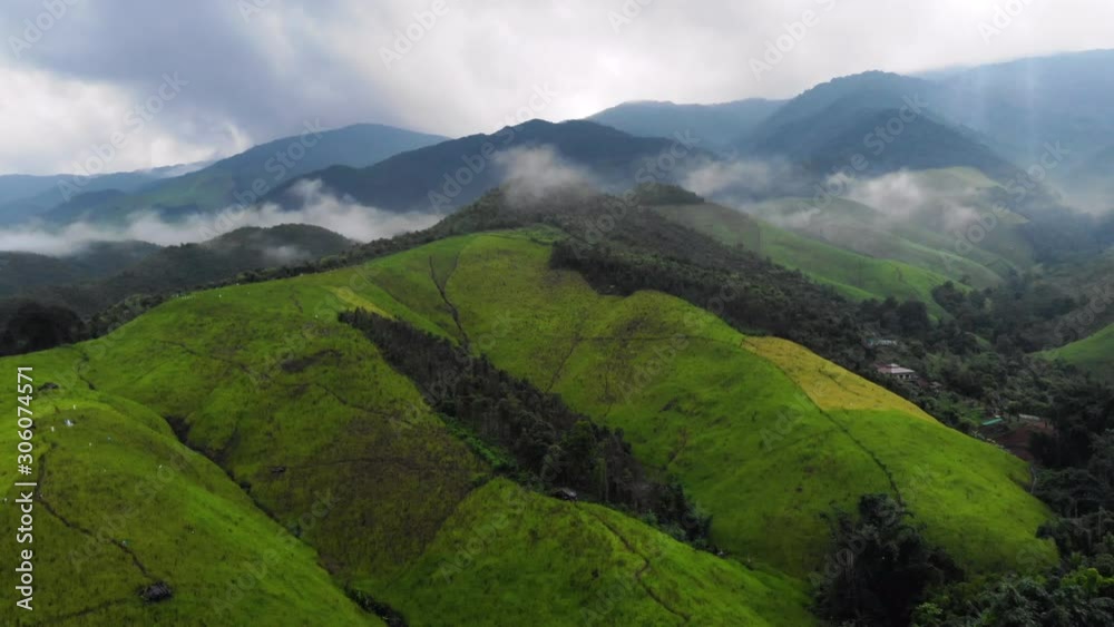 4k high angle drone shot orbiting above huge green summit big mountain, high altitude, foggy, sun light through cloud, landscape, cold and chilly weather, winter raining season, tropical climate 4k high angle drone shot orbiting above huge green summit big mountain, high altitude, foggy, sun light through cloud, landscape, cold and chilly weather, winter raining season, tropical climate