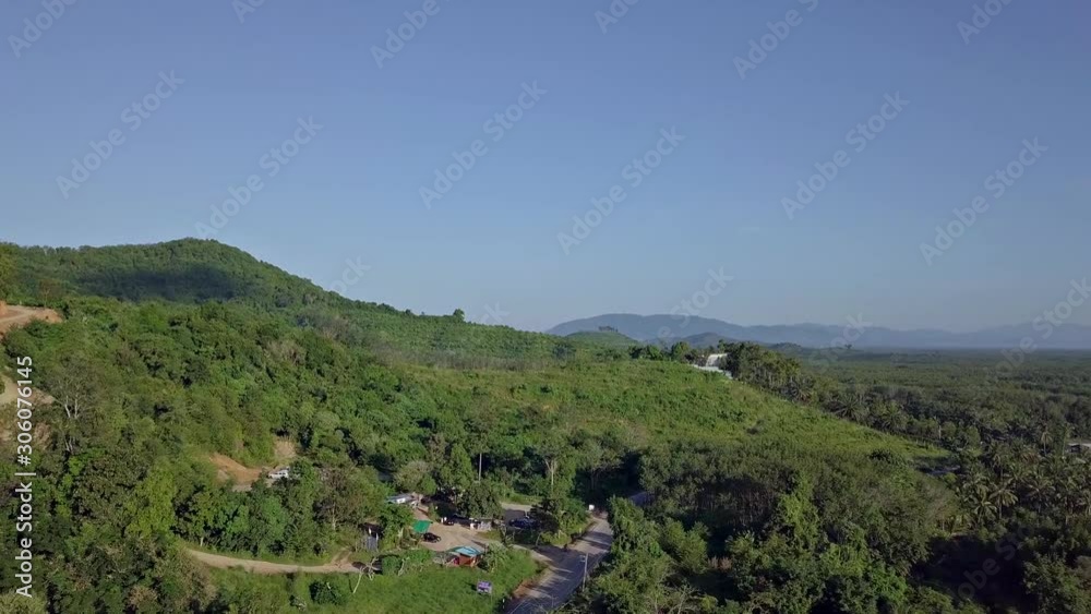 4K drone flight pass a small village on the hill with mountain all around on background in day time 4K drone flight pass a small village on the hill with mountain all around on background in day time