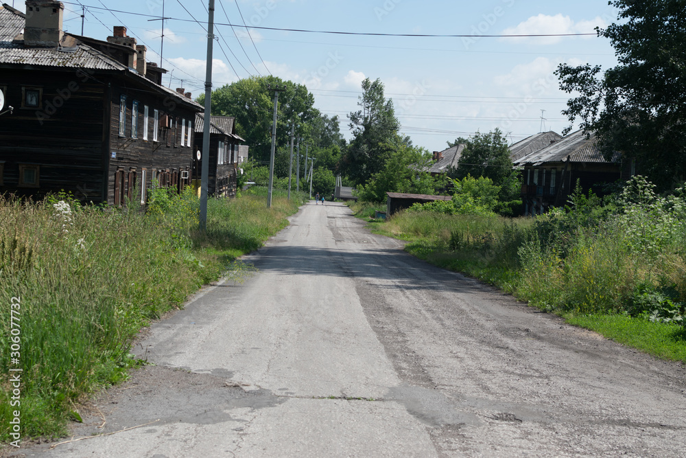 Old overgrown street in Prokopievsk with wooden houses