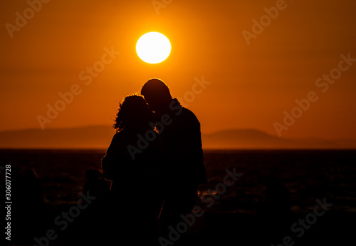 Happy couple outdoors in nature, soft sunny lights. Silhouette and love at sunset.