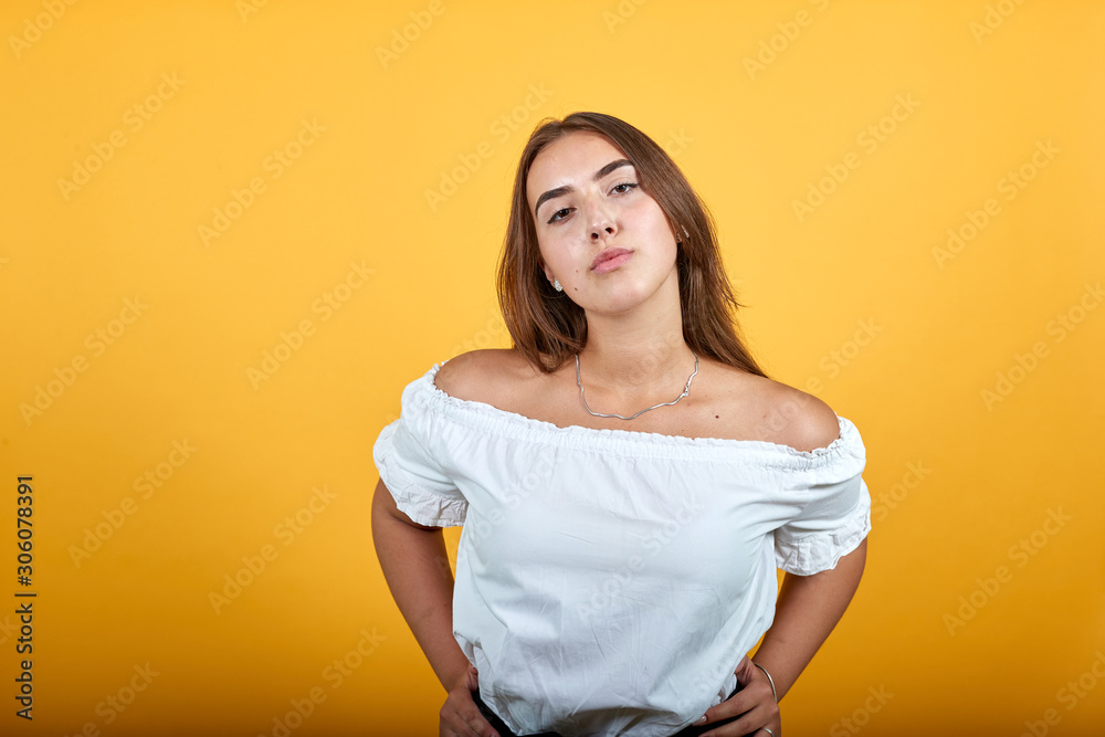 Attractive young woman blowing kiss at camera, looking charming isolated on orange background in studio in casual white shirt. People sincere emotions, lifestyle concept. Attractive young woman blowing kiss at camera, looking charming isolated on orange background in studio in casual white shirt. People sincere emotions, lifestyle concept.