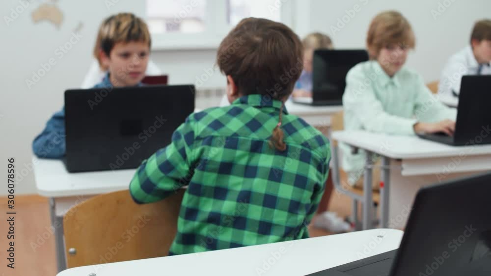Education at modern school, schoolboy got a good grade on test work, happy and positive emotion, boy brags about success with classmate.