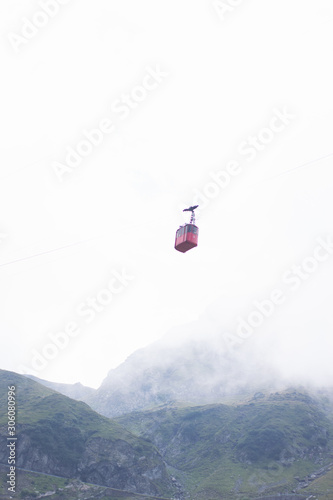 Cable car above green mountainous district on cloudy weather