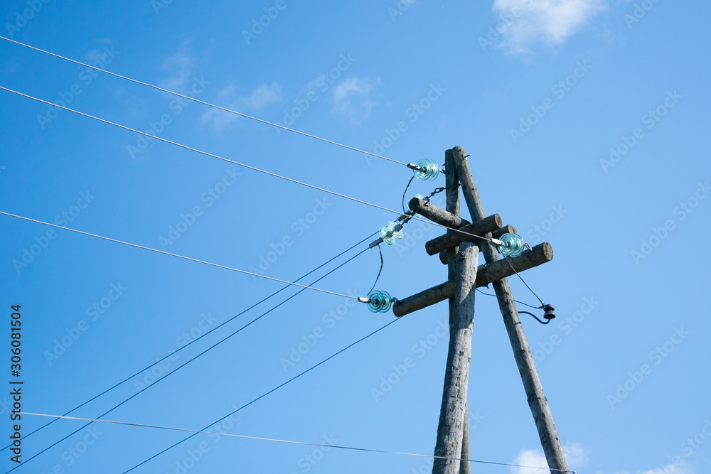 Old Electrical post with power line cables against blue sky Old Electrical post with power line cables against blue sky