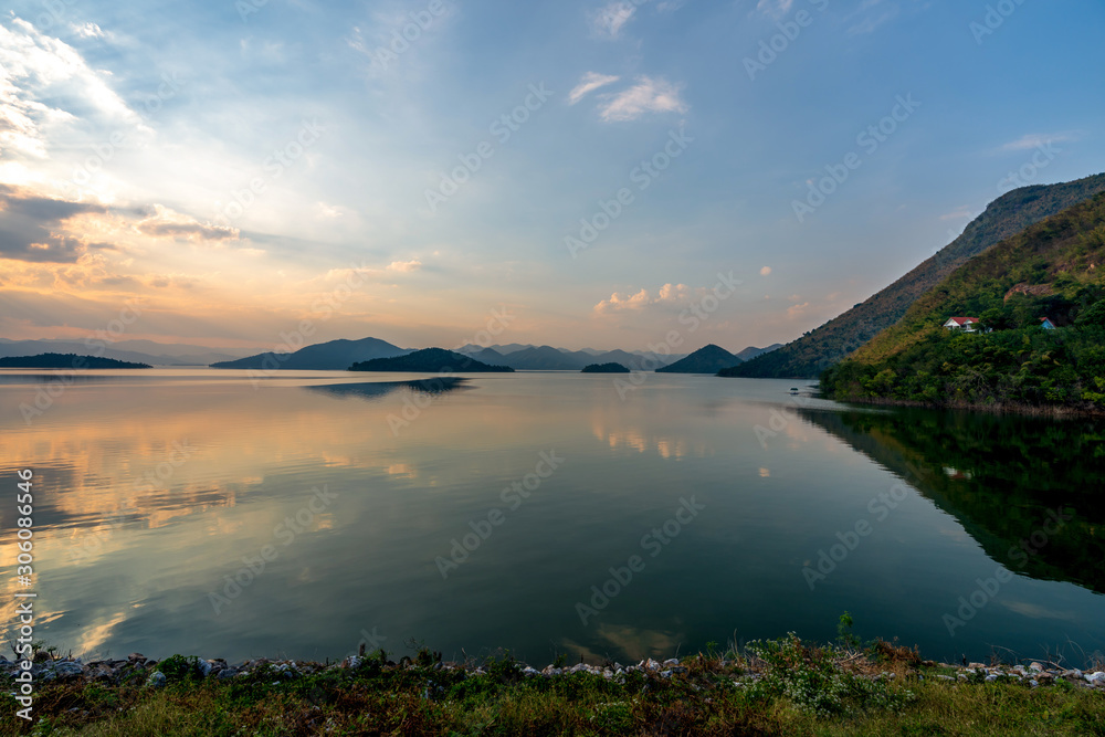 Obraz premium beautiful blue sky green forest mountains lake view at Kaeng Krachan National Park, Thailand. an idea for backpacker hiking on long weekend or a couple, family holiday activity camping relaxing
